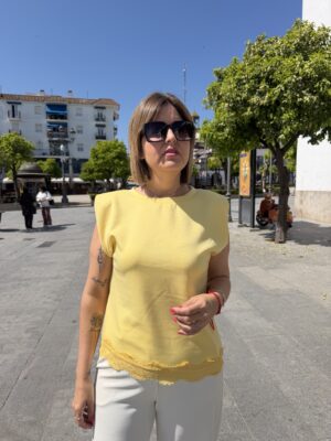 Camiseta hombreras y encaje amarilla.
